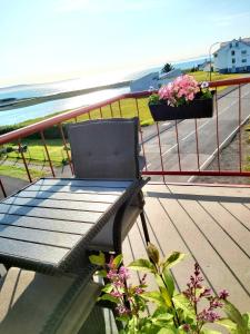 a chair sitting on a balcony overlooking the ocean at Gistiheimilið Ósbær in Blönduós