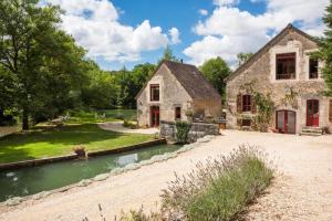 an old stone house with a pond in front of it at Water Mill - Private Lake - Fiber Wifi - Burgundy in Rix