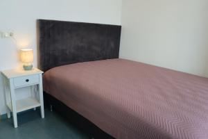 a bedroom with a bed and a night stand with a lamp at Gistiheimilið Ósbær in Blönduós +15 photos