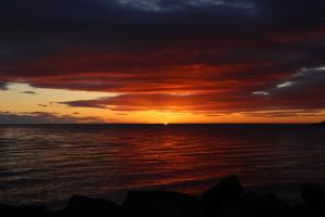a sunset over a body of water with the ocean at Gistiheimilið Ósbær in Blönduós