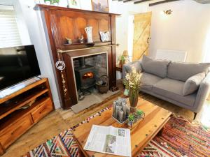 a living room with a couch and a fireplace at Eastend Cottage in Leyburn