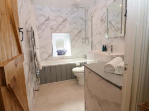 a bathroom with a sink and a toilet and a tub at Eastend Cottage in Leyburn +40 photos