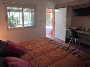 a bedroom with a large bed and a window at Refugio - Suite privada con jardín y parrilla en Chilecito in Chilecito