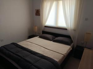 a small bedroom with a bed with a window at corali in Tersephanou