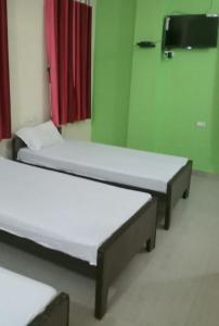 two beds in a room with a red and green wall at G d palace in Gwalior +10 photos