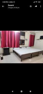 a bedroom with a large bed and red curtains at G d palace in Gwalior