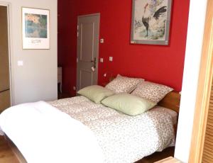 a bedroom with a bed and a red wall at Mas des Treilles - Chambre d'hôtes "Côté Villages" in Mane +10 photos