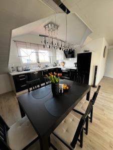 a black dining room table with chairs and a kitchen at Heimglück mit Ipf & Ruine in Bopfingen