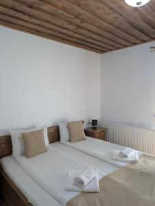 a white bed with two towels on top of it at Mateo Transalpina in Săsciori