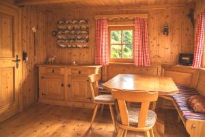 a wooden kitchen with a wooden table and chairs at Almhütte Santnerhof - Hochgebirgshütte 1750m - This is a remote high mountain hut in Virgen