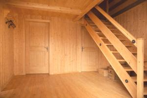 an attic room with a wooden staircase and a door at Almhütte Santnerhof - Hochgebirgshütte 1750m - This is a remote high mountain hut in Virgen +7 photos