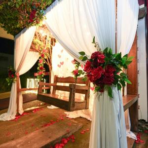 a wedding altar with red flowers and a white curtain at Hotel Vale da Serra in Parauapebas