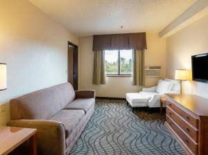 a living room with a couch and a tv at Oscoda Lakeside Hotel in Oscoda