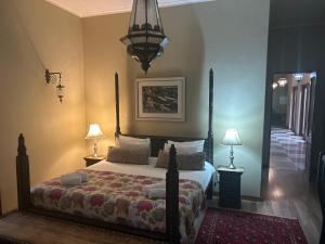 a bedroom with a bed and two lamps and a mirror at Willows Boutique Hotel in Pretoria