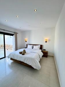 a bedroom with a large bed and a large window at Dar Youba, Luxe Villa Taghazout in Taghazout