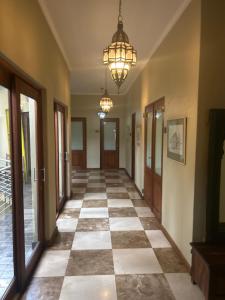 a hallway with a checkerboard floor and a chandelier at Willows Boutique Hotel in Pretoria