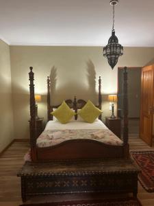 a bedroom with a bed with yellow pillows on it at Willows Boutique Hotel in Pretoria