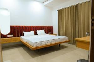 a bedroom with a bed with a wooden headboard at K D Motels in Patiāla