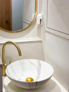a bathroom with a sink with a gold faucet at Euljiro Central 3BR Stay in Seoul +25 photos