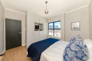 a bedroom with a large bed and a window at Cape on Porterfield in Cape Town