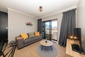 a living room with a couch and a table at Cape on Porterfield in Cape Town