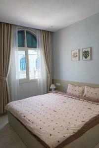 a bedroom with a large bed in front of a window at Leo'J Hotel & Apartment in Phú Quốc +9 photos