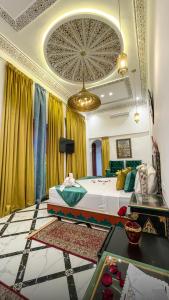 a bedroom with a large bed and a chandelier at Riad Lala Zehra in Fez