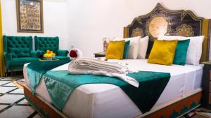 a bedroom with a large bed with green and yellow pillows at Riad Lala Zehra in Fez