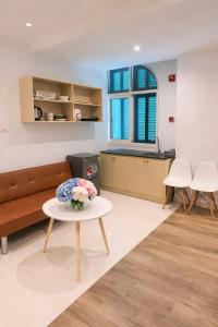 a living room with a table with a vase of flowers on it at Leo'J Hotel & Apartment in Phú Quốc