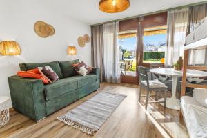 a living room with a green couch and a table at Cari'Stay in Portalban- Dessous