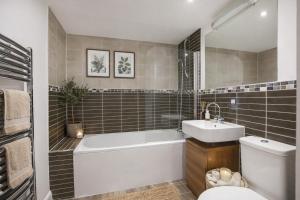 a bathroom with a tub and a sink and a toilet at Dixon's Yard, City Centre - Free Parking in York +10 photos