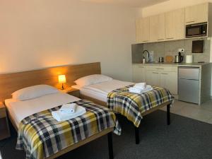 a hotel room with two beds and a kitchen at Krakstop apartamenty in Krakow
