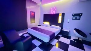 ein Schlafzimmer mit einem Bett und einem Stuhl in der Unterkunft Auto Hotel Via Uno in Boca del Río