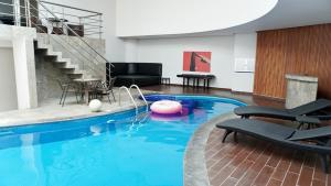 ein großer Pool mit Stühlen, einem Tisch und einer Treppe in der Unterkunft Auto Hotel Via Uno in Boca del Río