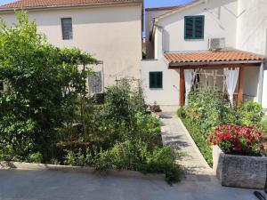 a garden in front of a house with flowers at Apartments Emil in Murter