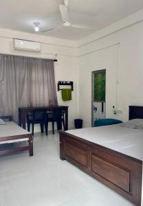 a bedroom with two beds and a table in it at Mapa Group Rest House in Kurunegala
