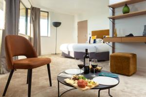 a hotel room with a table with food and wine at Best Western Hotel le Galice Aix-en-Provence in Aix-en-Provence