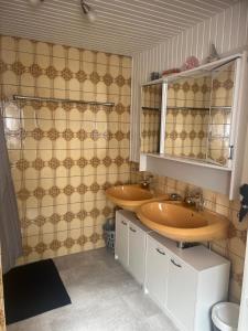 a bathroom with two sinks and a tiled wall at Beti Apartment in Nentershausen +17 photos
