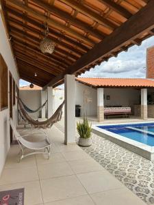 a patio with a hammock and a swimming pool at Recanto da Lapinha in Piranhas