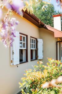 a house with two windows and purple flowers at Casa da Avó Lina by Quantique in Vieira do Minho