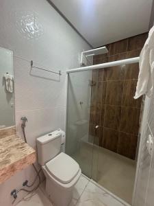 a bathroom with a toilet and a glass shower at Recanto da Lapinha in Piranhas