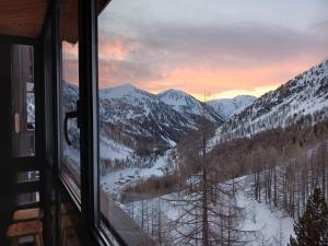 a view of a snow covered mountain from a window at Studio Isola 2000 in Isola 2000