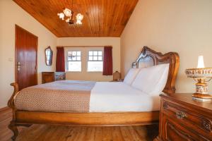 a bedroom with a large bed with a wooden headboard at Casa da Avó Lina by Quantique in Vieira do Minho