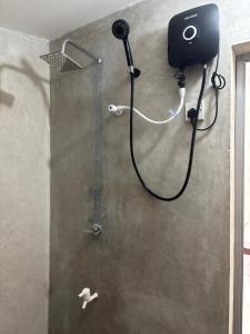 a shower in a bathroom with a hair dryer at Mapa Group Rest House in Kurunegala +18 photos