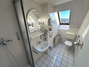 a white bathroom with a sink and a toilet at Gästehaus am Harz in Goslar