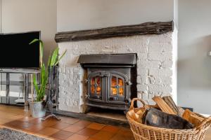 a stone fireplace in a living room with a tv at 3 Bed in Stratford St. Andrew oc-swint in Farnham