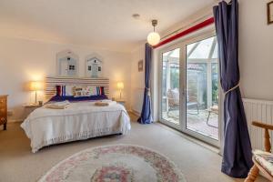 a bedroom with a bed and a sliding glass door at 3 Bed in Stratford St. Andrew oc-swint in Farnham