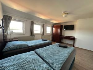 a hotel room with two beds and a television at Gästehaus am Harz in Goslar