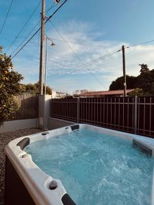 a hot tub on a patio with a fence at Zouf House Luxury Stay with Jacuzzi in Panayía Mesosporítissa