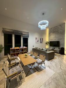 a living room with a couch and a table and chairs at Baby Blue pool villa in Ban Bo Prakhon